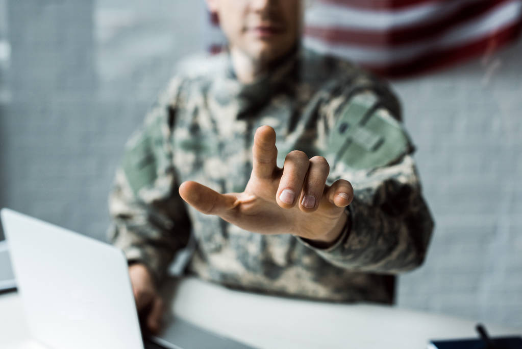 επιλεκτική εστίαση του ανθρώπου σε καμουφλάζ ομοιόμορφη δείχνοντας με το δάχτυλο  - Φωτογραφία, εικόνα