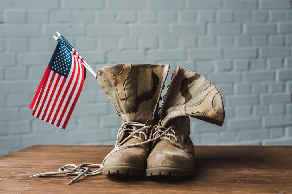 botas militares y banderas americanas con estrellas y rayas en la superficie de madera
  - Foto, imagen