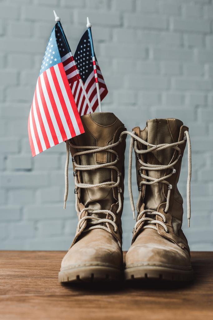 askeri botlar ve ahşap masa üzerinde yıldız ve çizgili Amerikan bayrakları  - Fotoğraf, Görsel