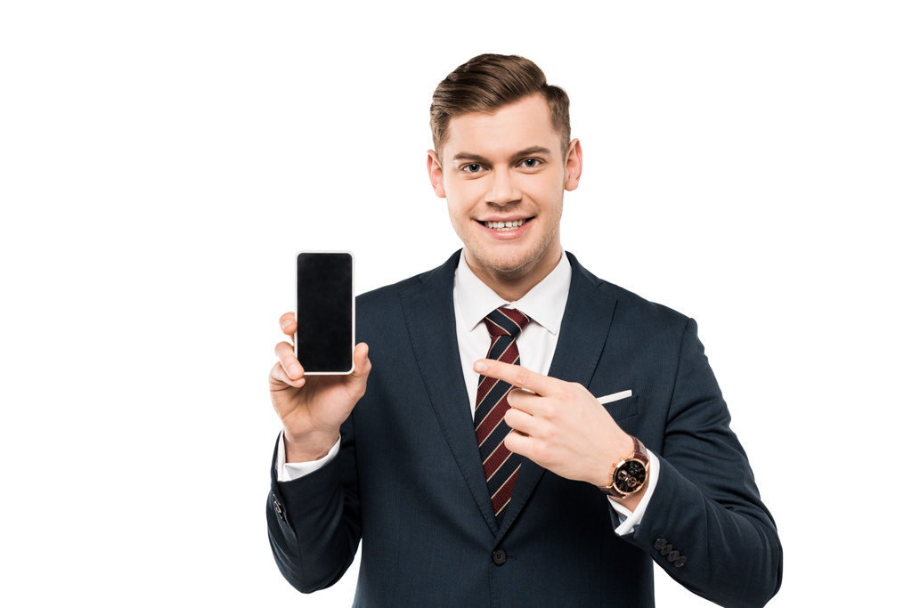 happy businessman in suit pointing with finger at smartphone with blank screen isolated on white  - Photo, Image