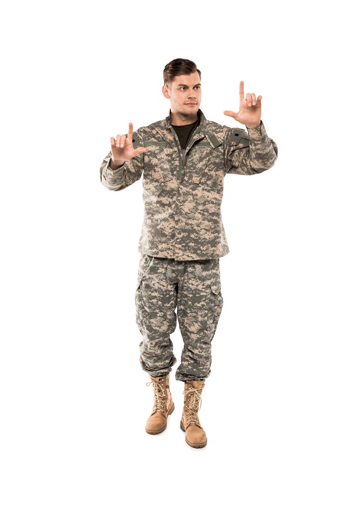 pohledný muž ve vojenském uniformním gestikulován na bílém  - Fotografie, Obrázek