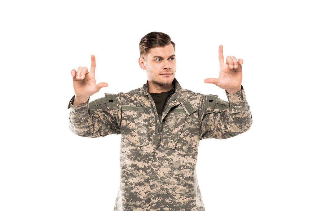 homem bonito em uniforme militar apontando com os dedos isolados em branco
  - Foto, Imagem