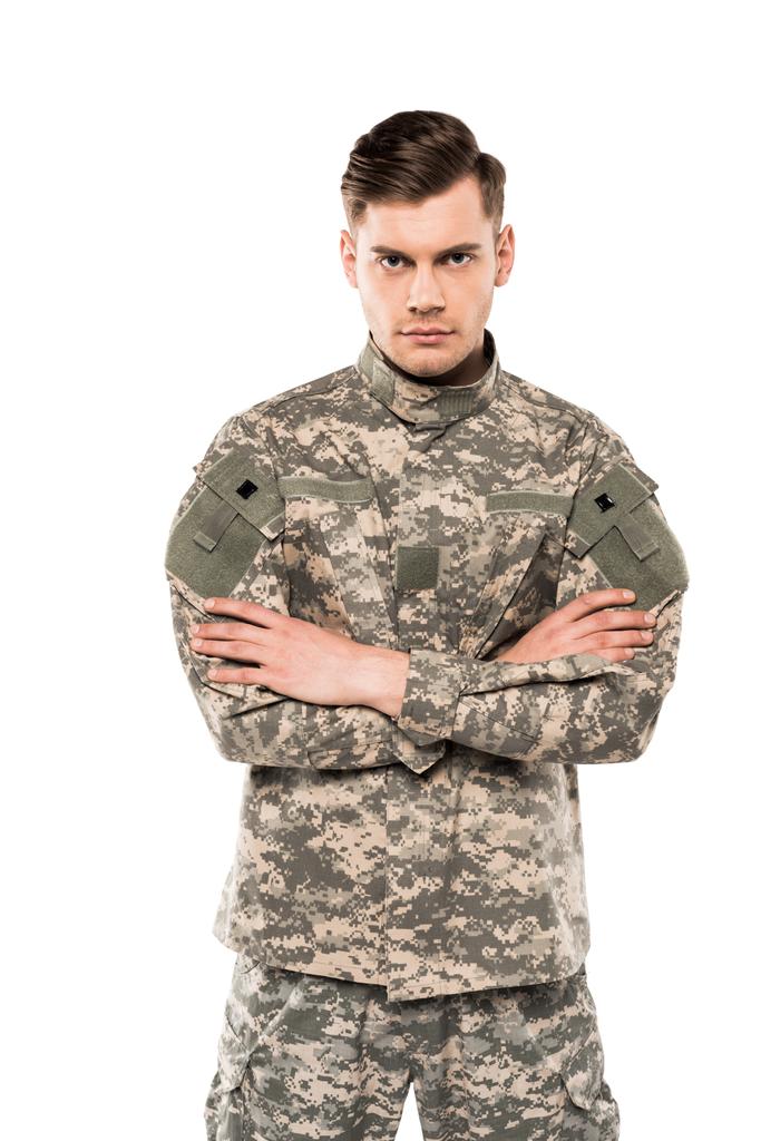 soldat sérieux en uniforme debout avec les bras croisés isolés sur blanc
  - Photo, image