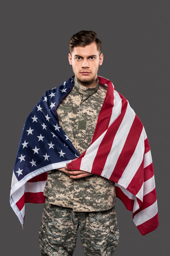 schöner Mann in Militäruniform mit amerikanischer Flagge isoliert auf grau  - Foto, Bild