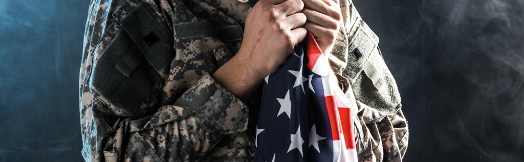 Panoramaaufnahme eines Soldaten mit amerikanischer Flagge auf schwarz mit Rauch  - Foto, Bild