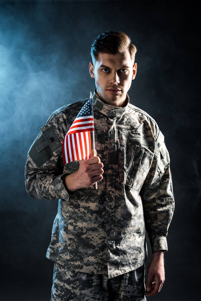 kendinden emin asker duman ile siyah amerikan bayrağı tutan  - Fotoğraf, Görsel