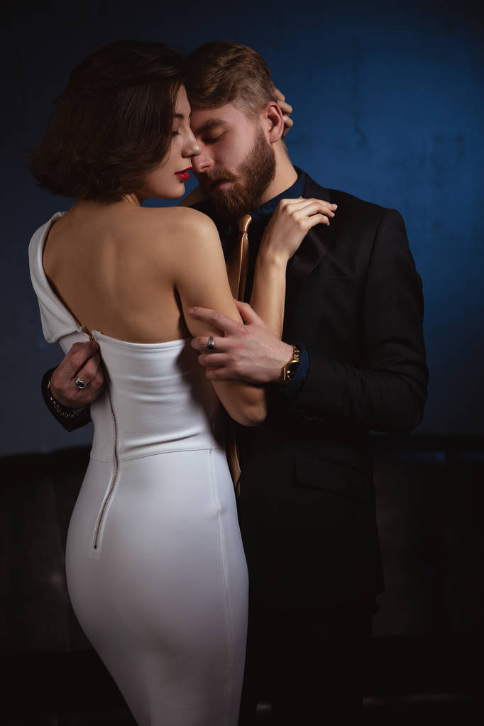 hombre apasionadamente abrazando chica tratando de desabrochar su vestido
 - Foto, imagen