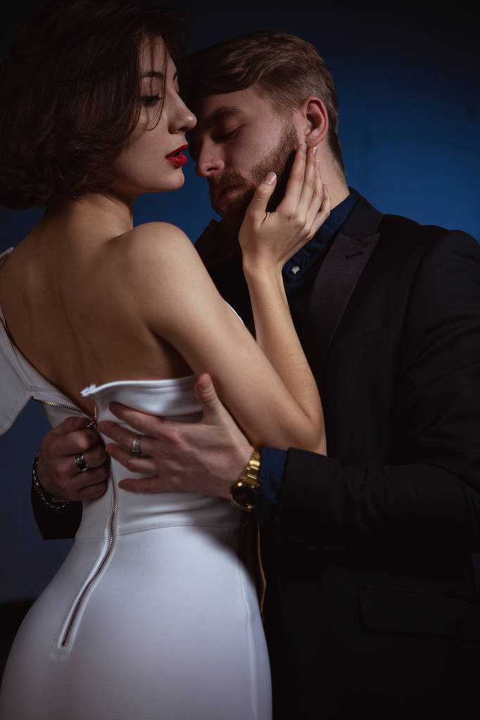muž v záchvatu vášně rozepne šaty mladé ženy, která se ho dotýká - Fotografie, Obrázek
