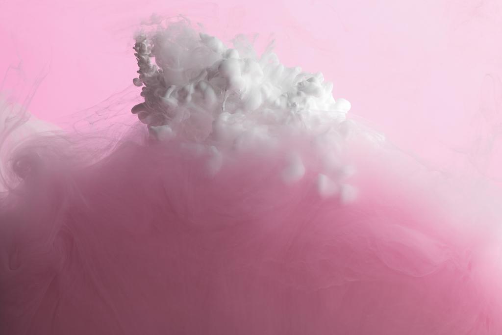 Vista de cerca de la mezcla de pintura blanca y rosa en agua aislada en rosa
 - Foto, Imagen