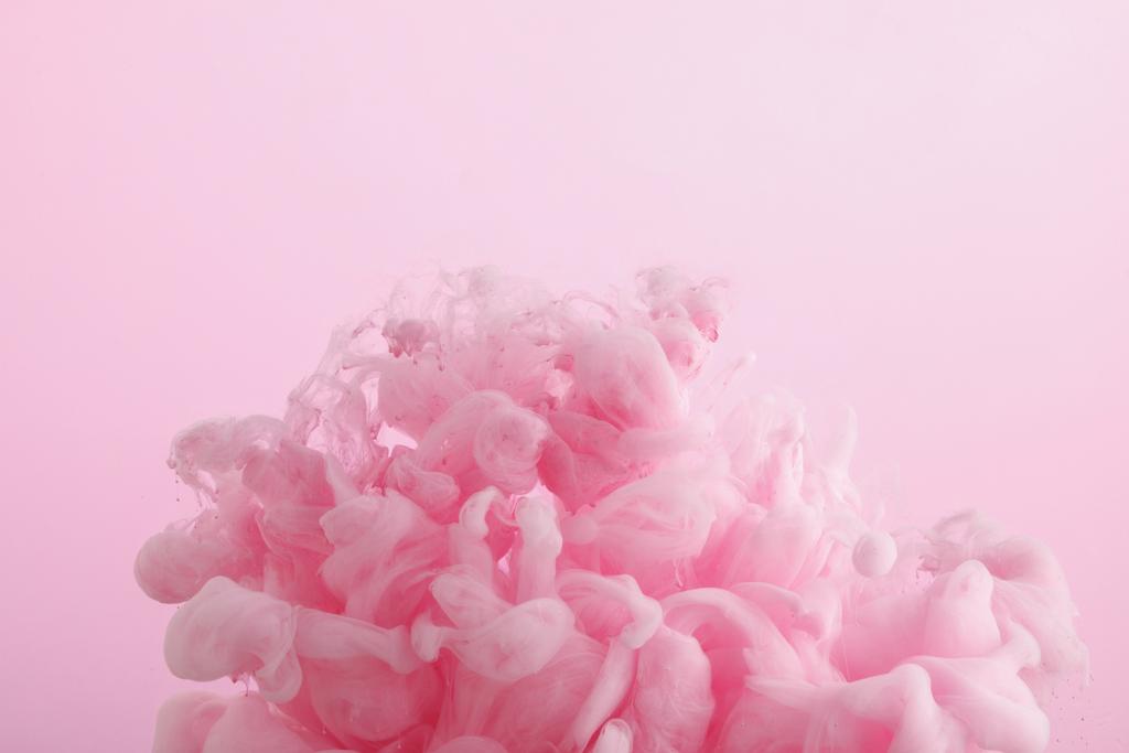 Nahaufnahme von rosa Farbwirbeln im Wasser isoliert auf rosa - Foto, Bild