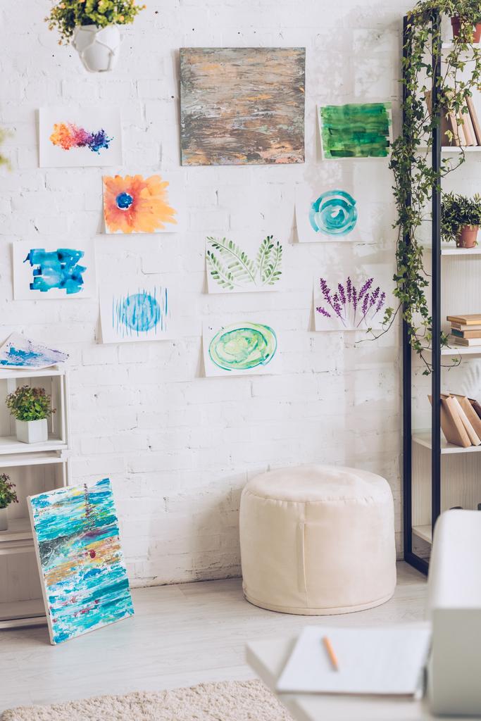φωτεινό δωμάτιο με Πράσινη γλάστρα φυτά και πολύχρωμα ζωγραφική σε λευκό τοίχο - Φωτογραφία, εικόνα