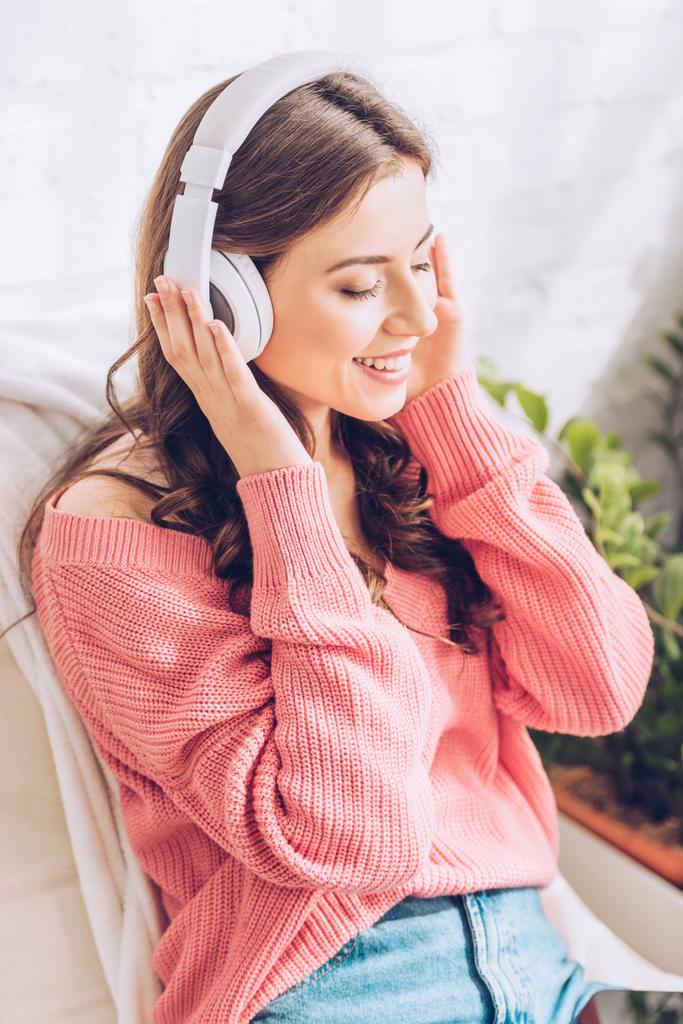 piękna dziewczyna uśmiechnięta i słuchanie muzyki w słuchawkach z zamkniętymi oczami - Zdjęcie, obraz