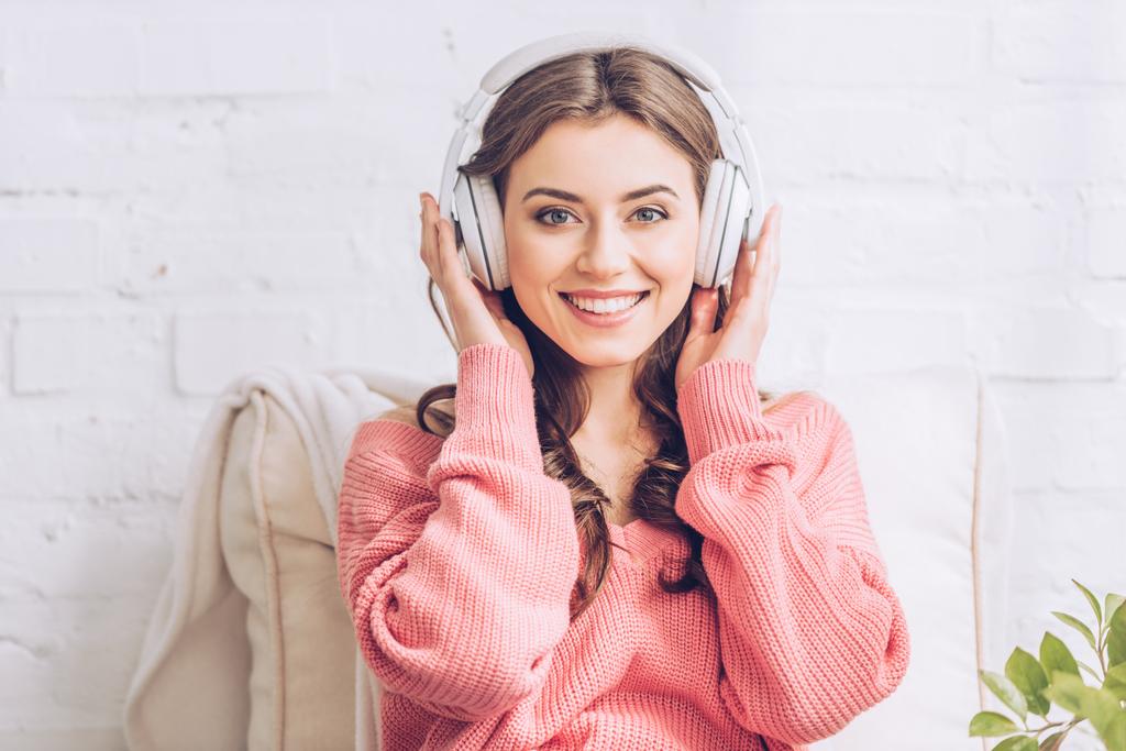 Gyönyörű fiatal nő hallgat zenét a fejhallgatót, és látszó-on fényképezőgép - Fotó, kép