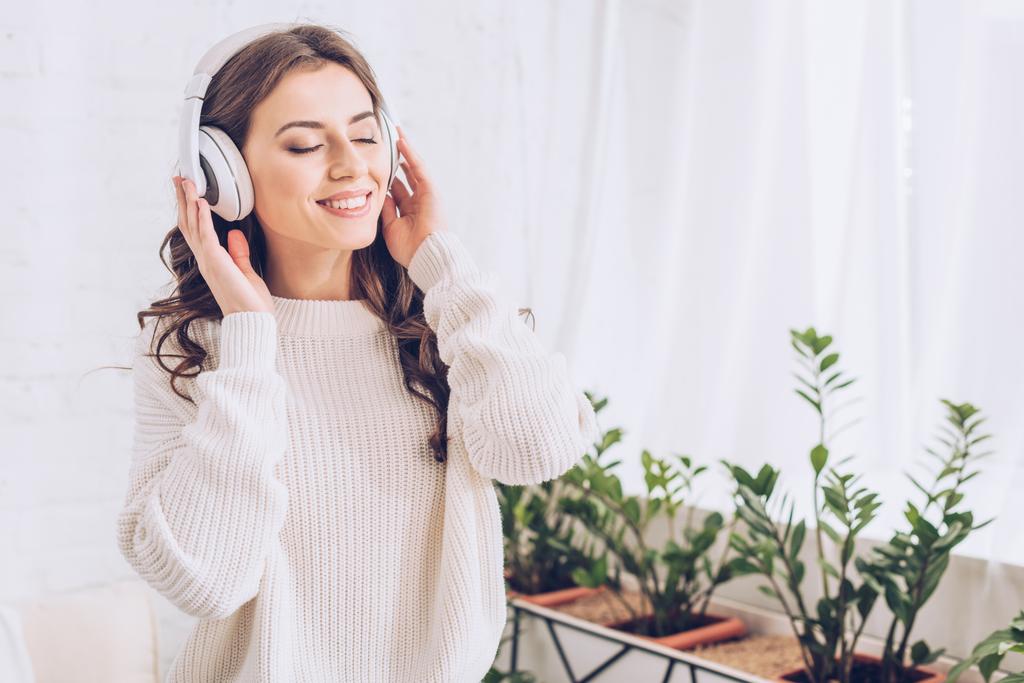 jeune femme heureuse écoutant de la musique dans des écouteurs avec les yeux fermés
 - Photo, image