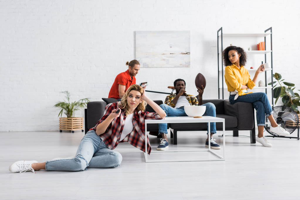Selektivní zaměření nelibě ženy ležící na stole a přidržování větší kontroly v obývacím pokoji - Fotografie, Obrázek