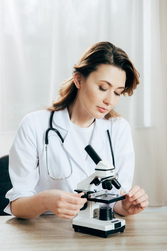 врач в белом халате с помощью микроскопа в клинике
 - Фото, изображение