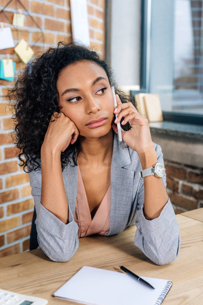 reflexiva afroamericana Casual mujer de negocios hablando en el teléfono inteligente
 - Foto, imagen