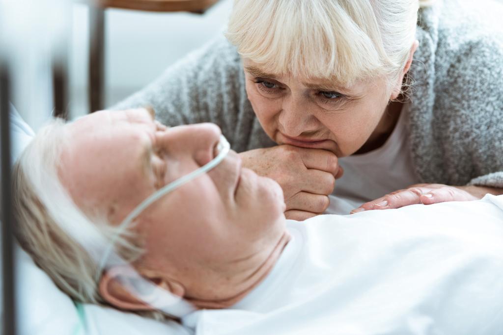 сумна старша жінка з чоловіком у комі в клініці
 - Фото, зображення