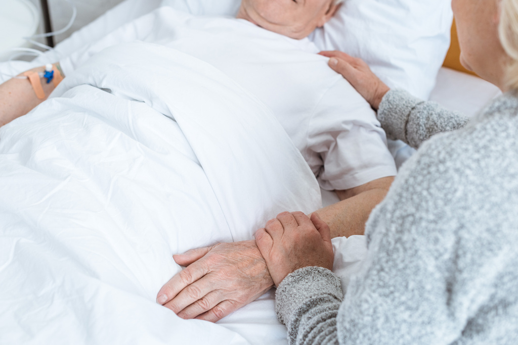частковий погляд на старшу жінку з хворим чоловіком у клініці
 - Фото, зображення