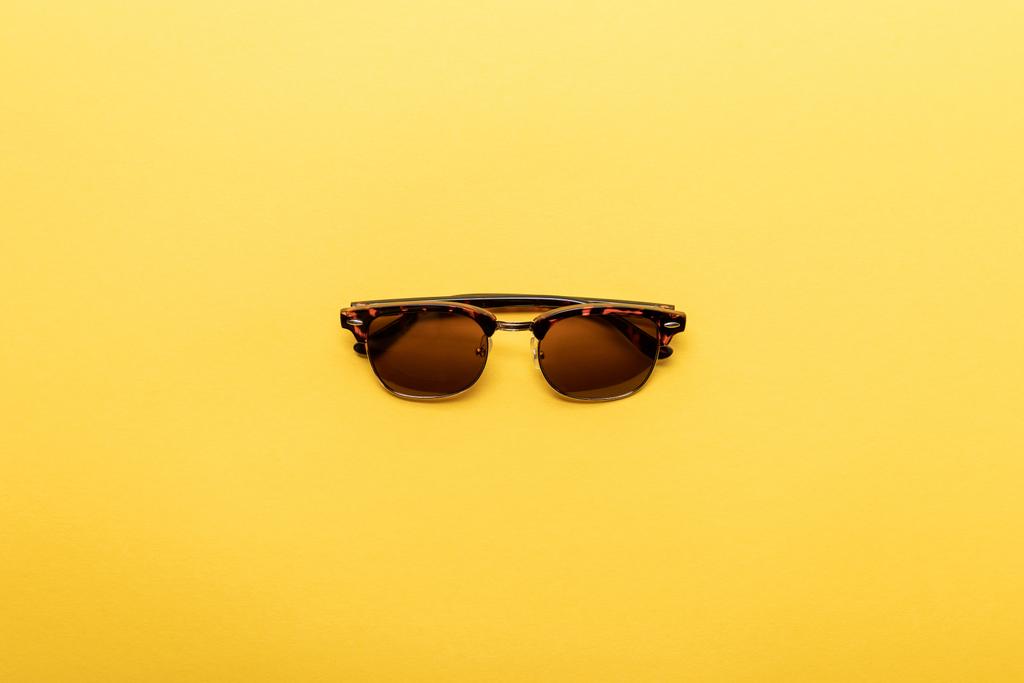 вид сверху на модные солнцезащитные очки на желтом фоне
 - Фото, изображение