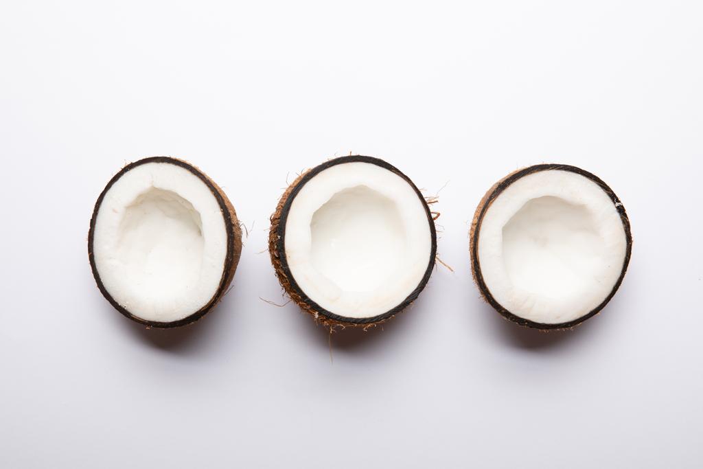 vista superior de metades de coco maduro no fundo branco com espaço de cópia
 - Foto, Imagem