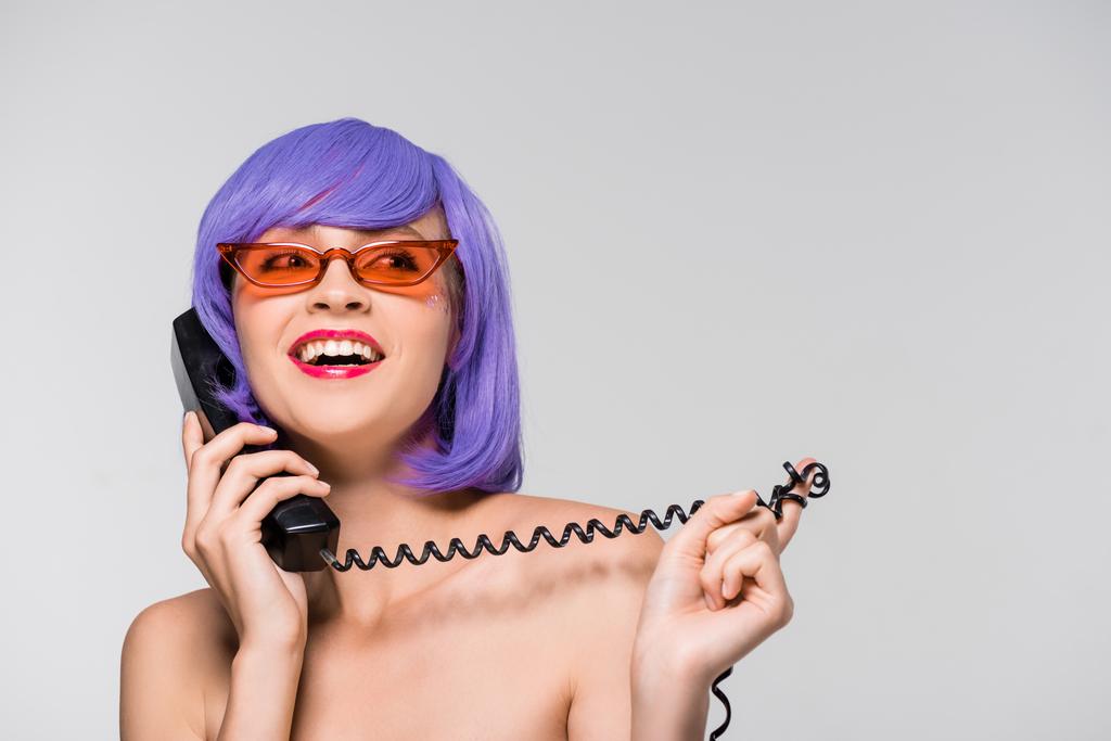 happy woman in purple wig talking on retro telephone, isolated on grey - Photo, Image