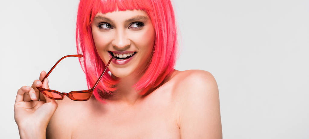 κομψό κορίτσι σε ροζ περούκα και γυαλιά ηλίου απομονώνονται σε γκρι - Φωτογραφία, εικόνα