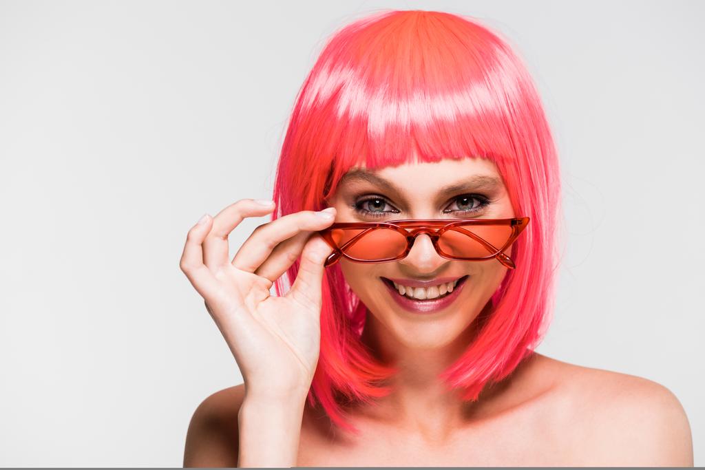 красивая улыбающаяся девушка в розовом парике и солнечных очках, изолированных на сером
 - Фото, изображение