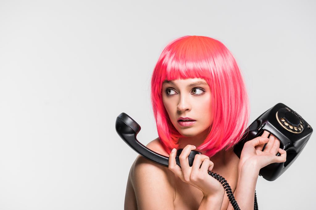 stylish beautiful woman in pink wig holding vintage telephone, isolated on grey - Photo, Image