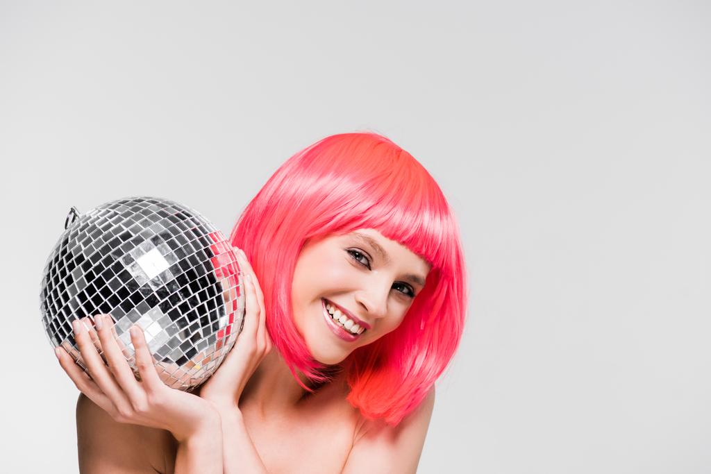 χαμογελαστός κορίτσι σε ροζ περούκα κρατώντας ντίσκο μπάλα, απομονωμένη σε γκρι - Φωτογραφία, εικόνα