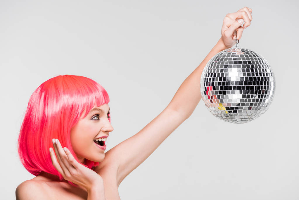izgatott lány rózsaszín paróka gazdaság disco labdát, izolált szürke - Fotó, kép