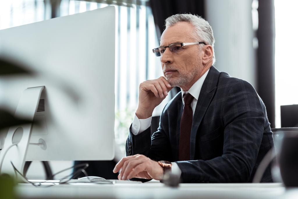 selective focus of businessman in glasses looking at computer monitor  - Photo, Image