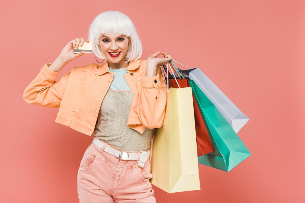 Atrakcyjna dziewczyna w białej peruce z torby na zakupy i karty kredytowej, izolowane na różowym - Zdjęcie, obraz