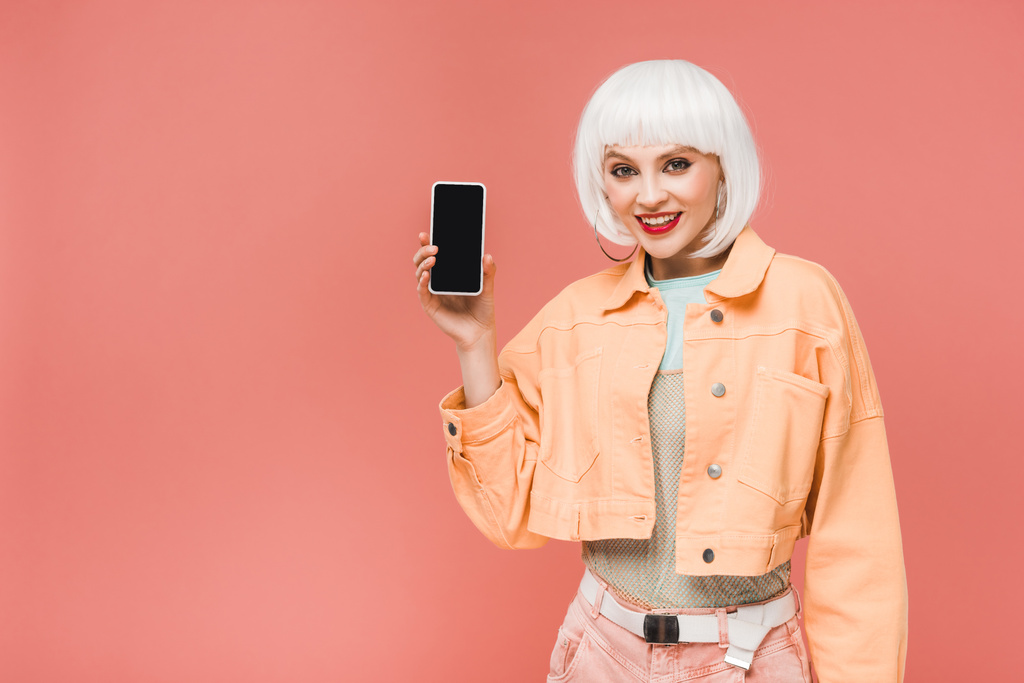 piękna kobieta pokazując smartfon z pustym ekranem, izolowane na różowym - Zdjęcie, obraz