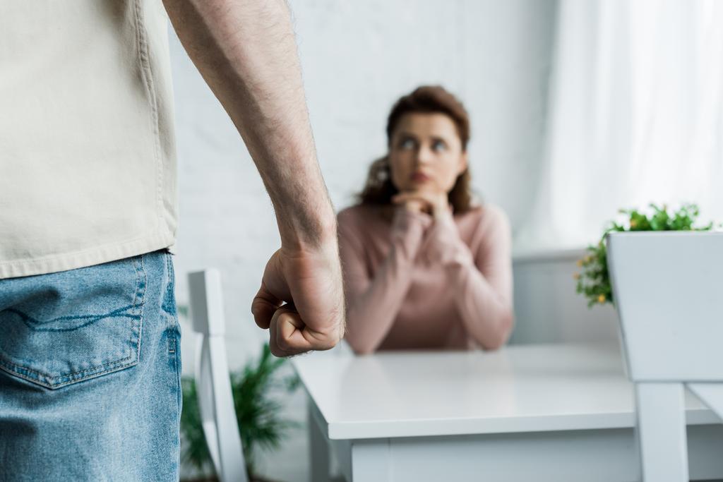 selektywne skupienie Gniewnego człowieka zagrażającego pięścią stojąc w pobliżu kobiety  - Zdjęcie, obraz