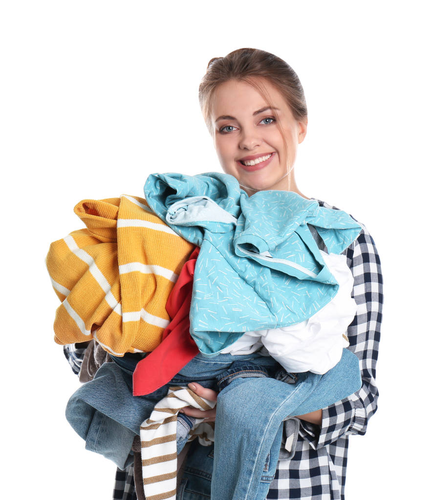 Happy young woman holding pile of dirty laundry on white background - Photo, Image