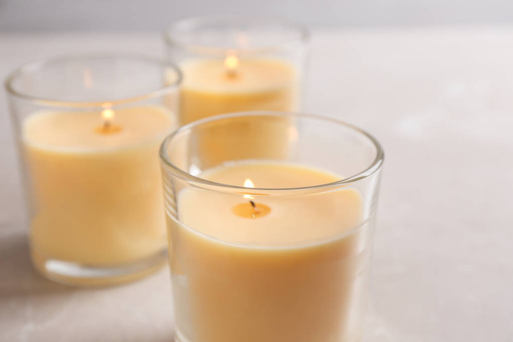 Три горящих свечи в стаканах на столе
 - Фото, изображение