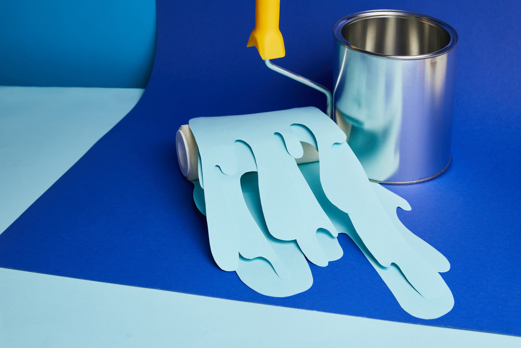 metal shiny can and roller with dripping paper cut paint on bright blue background - Photo, Image