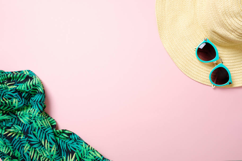 Strohhut, Sonnenbrille, Schal auf pastellrosa Hintergrund mit Kopierplatz für Text. Sommer Damenmode Outfit, Strandsachen, Urlaub Accessoires. Reise- oder Urlaubskonzept von oben, flach gelegt - Foto, Bild