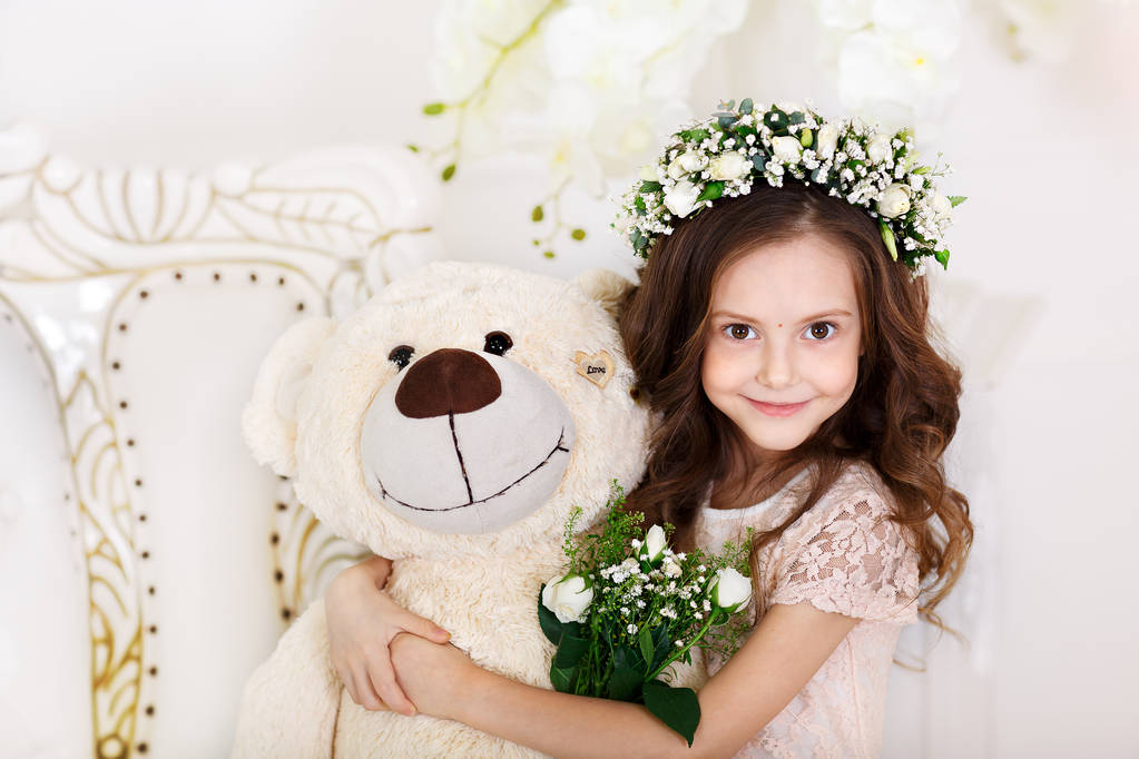 Ritratto di una graziosa bambina con una corona di fiori sulla testa che guarda il camer. Concetto infanzia felice. Primo piano
 - Foto, immagini