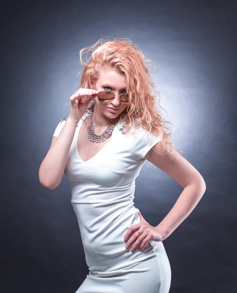 modny blond kobieta w białej sukni, patrząc przez okulary - Zdjęcie, obraz