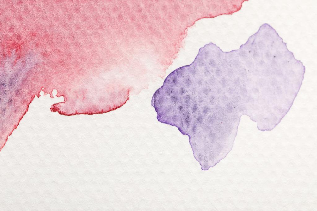 close up view of purple and red watercolor pale paint spills on white background - Photo, Image
