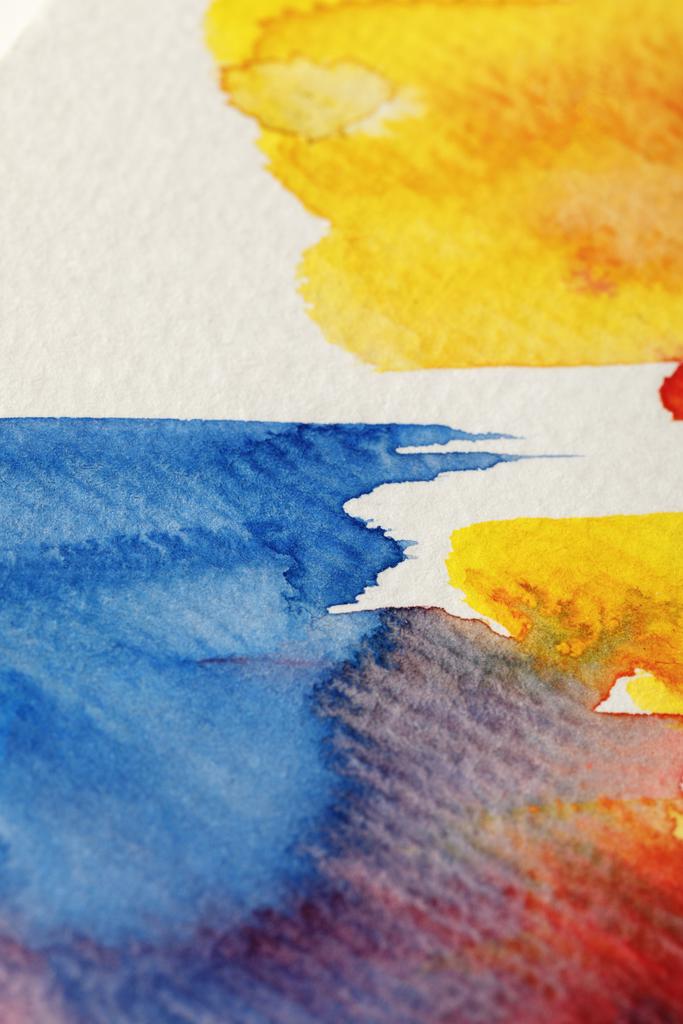 Close-up weergave van geel, blauw en rood aquarel verf penseelstreken op witte achtergrond - Foto, afbeelding