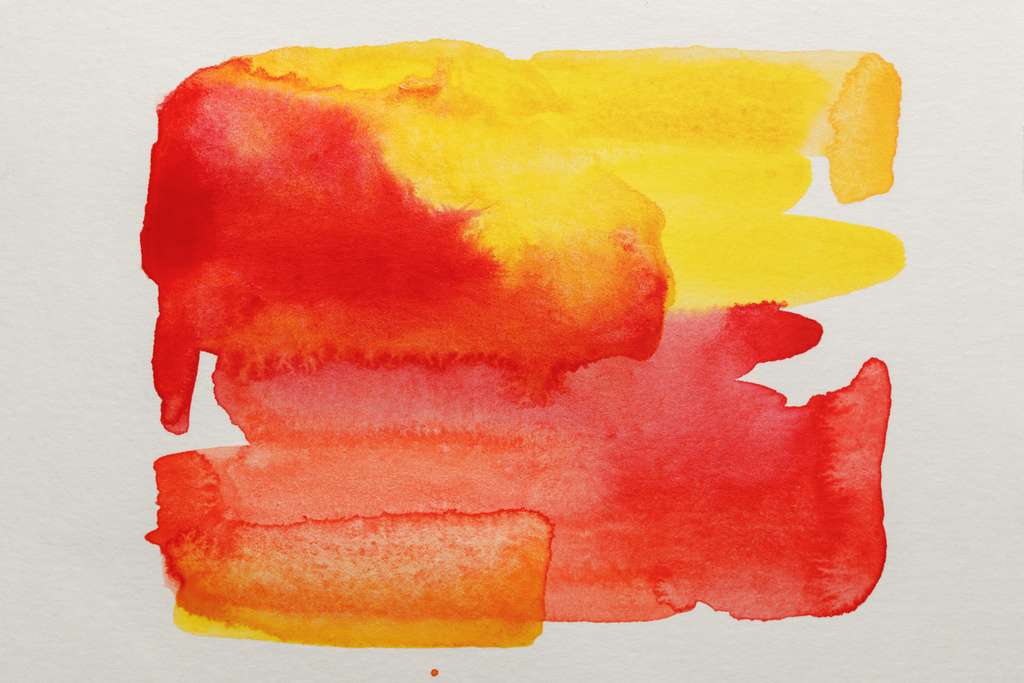 top view of yellow and red watercolor paint spills on white paper - Photo, Image