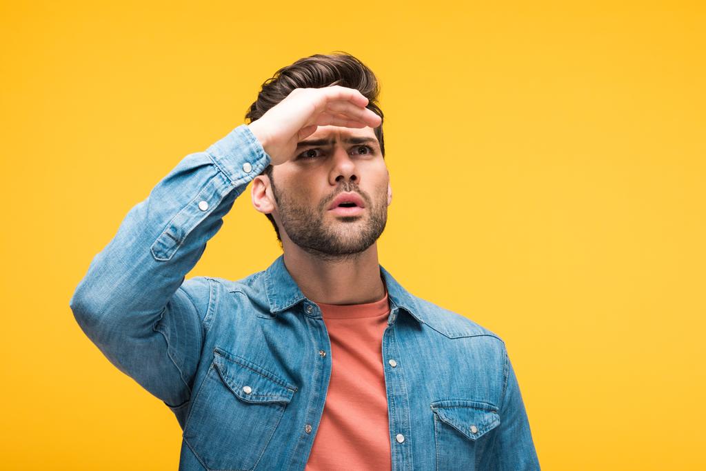 Verwirrter gutaussehender Mann mit Hand auf der Stirn isoliert auf gelb - Foto, Bild