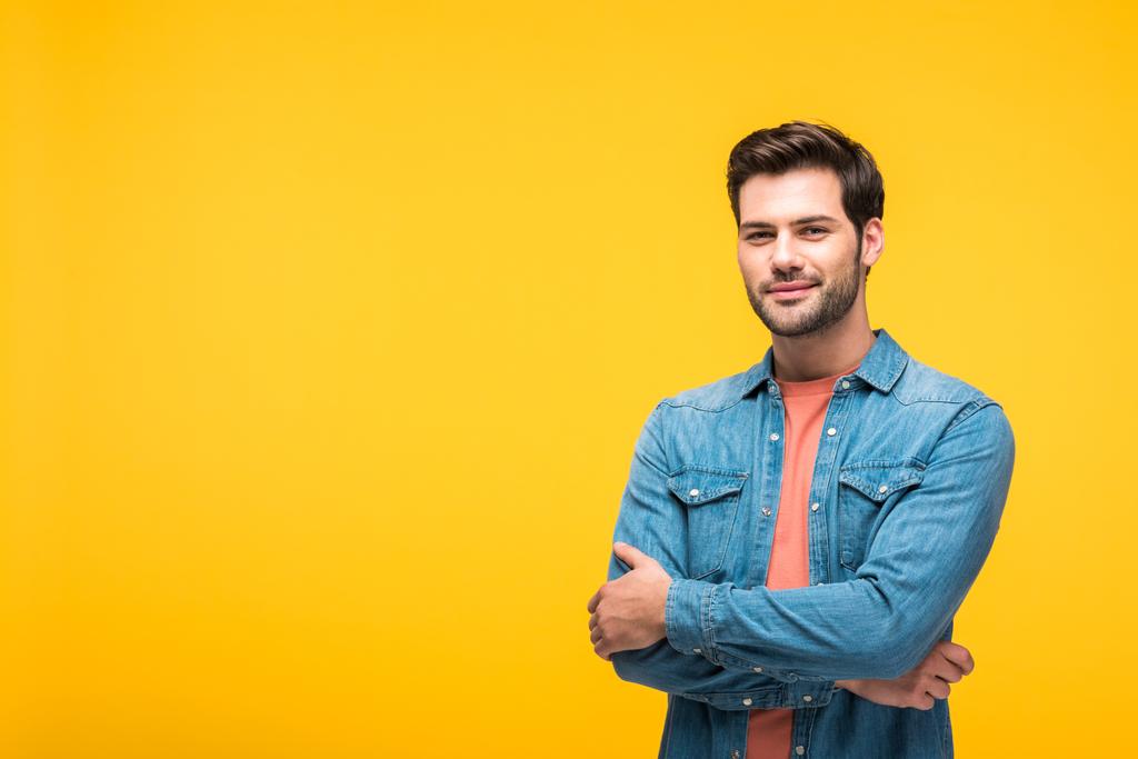 happy handsome man with crossed arms looking at camera isolated on yellow - Photo, Image