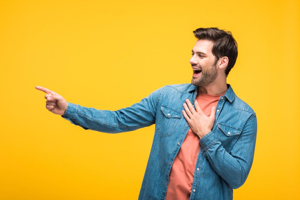 bel homme riant et pointant du doigt isolé sur jaune
 - Photo, image
