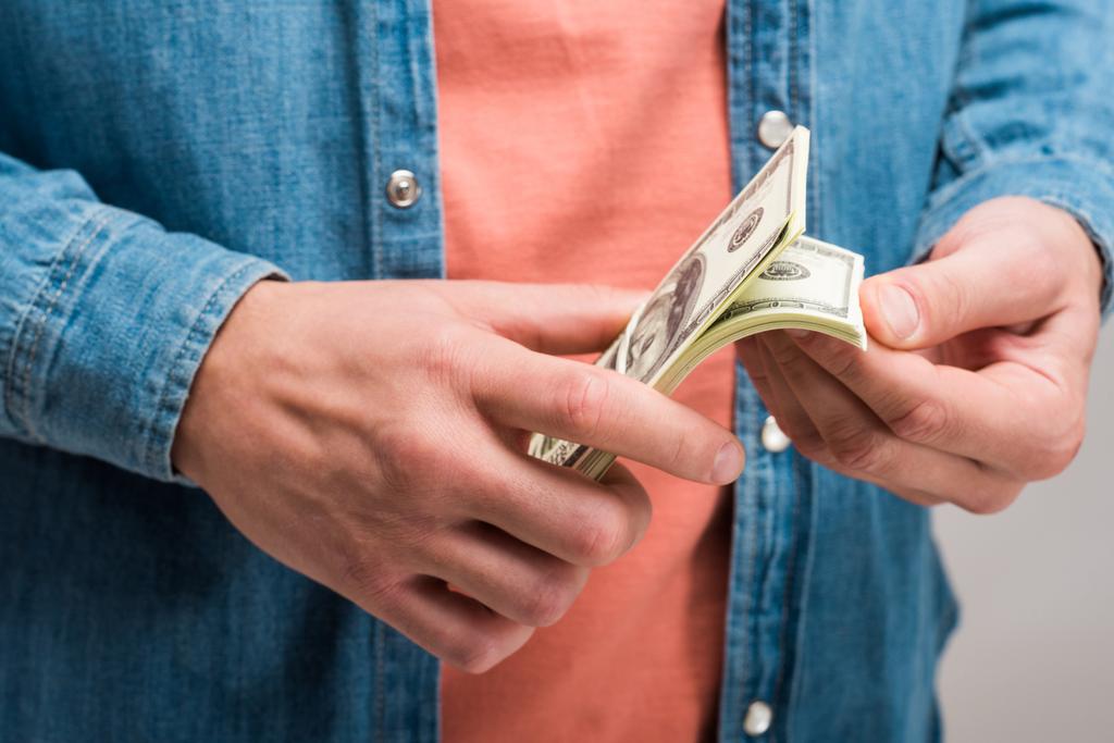 Избитый вид человека, считающего деньги на сером
 - Фото, изображение