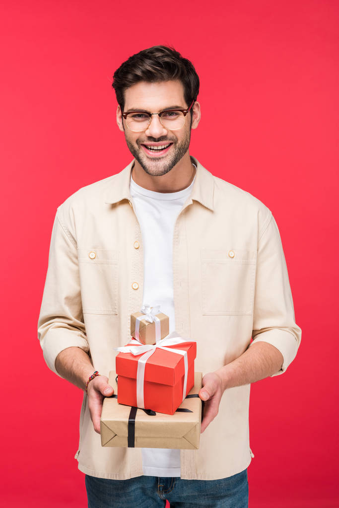 schöner lächelnder Mann mit Geschenken auf rosa - Foto, Bild