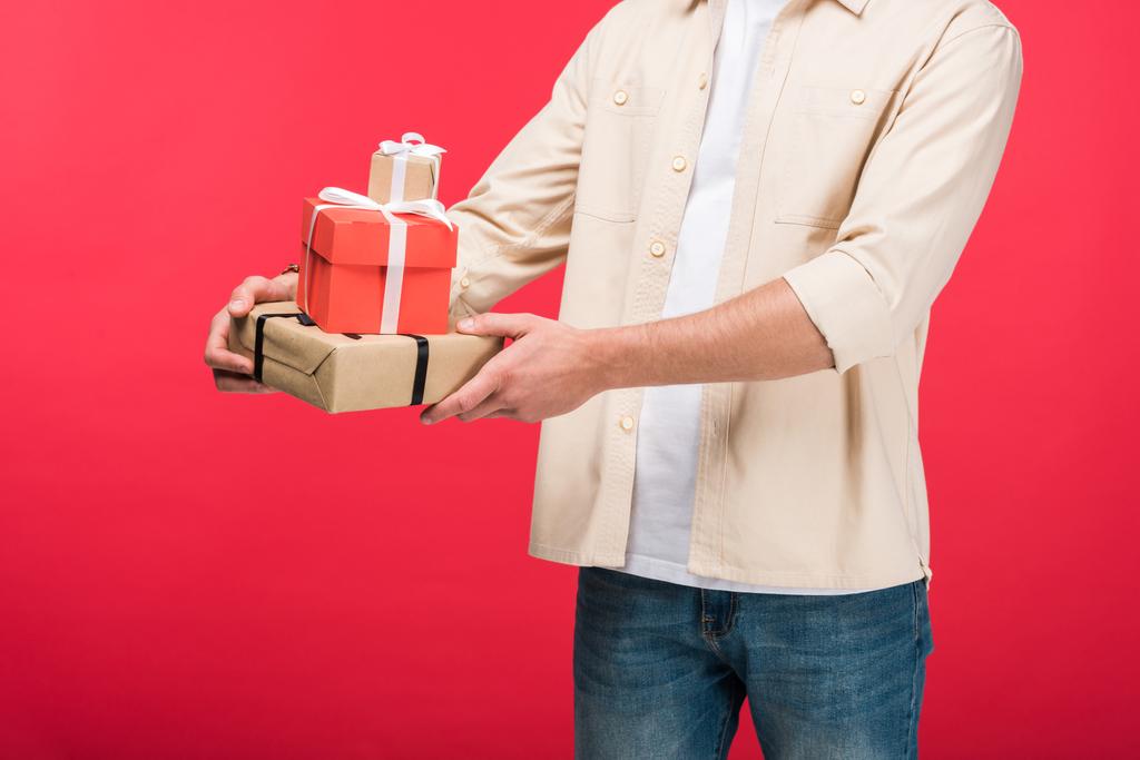 Обрезанный вид мужчины с подарками на розовом
 - Фото, изображение